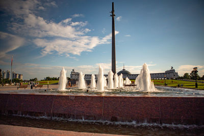 Fountain in city against sky