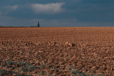 Hay bales on field against sky