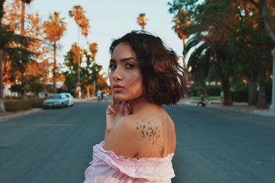 Close-up of young woman against trees