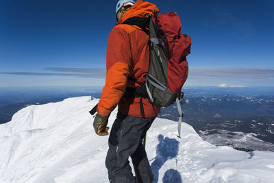 A man climbs to the summit of mt. hood in oregon.