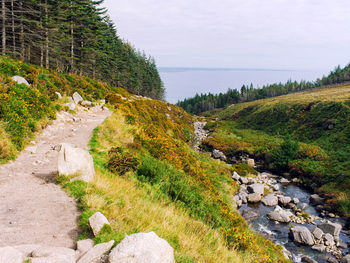 Scenic view of rocks by sea against sky