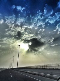 Empty road against cloudy sky