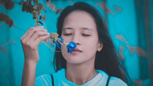 Close-up of woman smelling flower