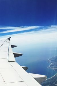 Cropped image of airplane against blue sky