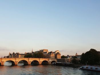 Arch bridge over river against clear sky