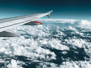 Airplane flying over cloudscape against sky