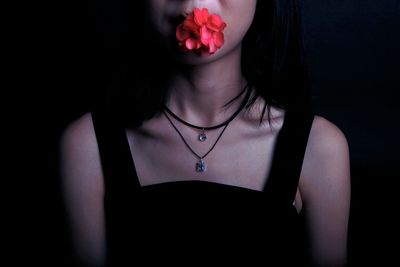 Close-up of beautiful woman against black background