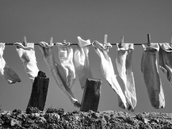 Clothes drying on wooden post against sky