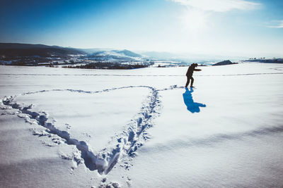 Full length of person on snow covered land against sky