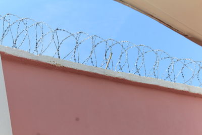 Low angle view of barbed wire against sky