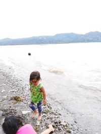 Full length of girl on beach against sky