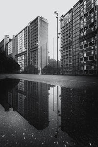 Reflection of buildings in puddle on street