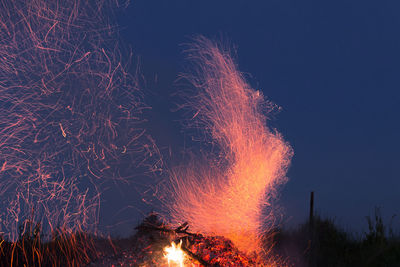 Firework display against sky at night