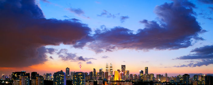 View of cityscape against cloudy sky during sunset