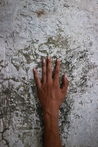 Close-up of hand touching wall