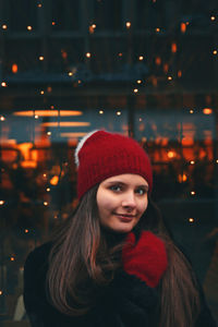 Portrait of smiling woman in illuminated park during winter at night