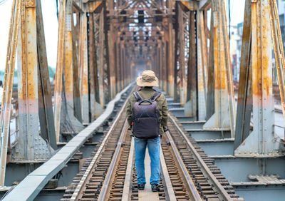 Rear view of man standing on railroad track