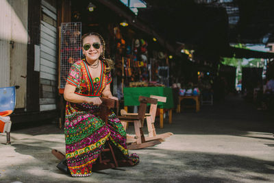 Portrait of smiling woman sitting on rocking horse