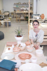 Portrait of smiling entrepreneur sitting in pottery store