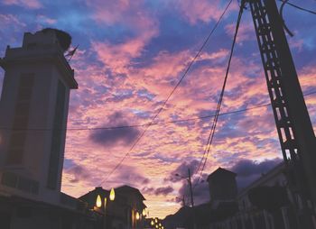 Low angle view of silhouette buildings against sunset sky