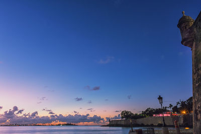Low angle view of illuminated building against sky during sunset