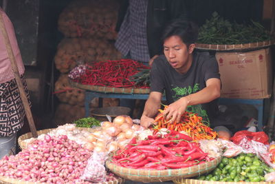 View a man selling vegetable in a traditional market, in indonesia