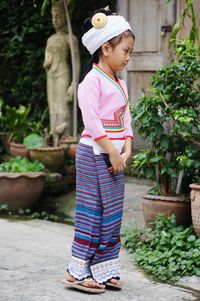 Full length of girl standing against plants