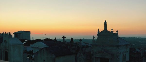 Buildings against clear sky during sunset in city