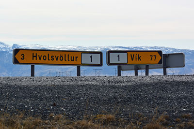 Information sign on road against sky