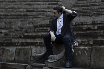 Thoughtful young man sitting on steps 