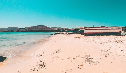 Scenic view of beach against clear blue sky