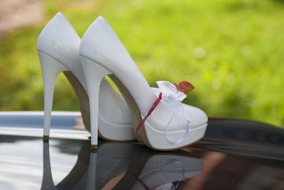 Close-up of high heels shoes with garter on car hood