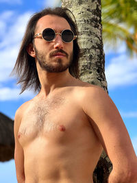 Portrait of shirtless young man wearing sunglasses in mauritius