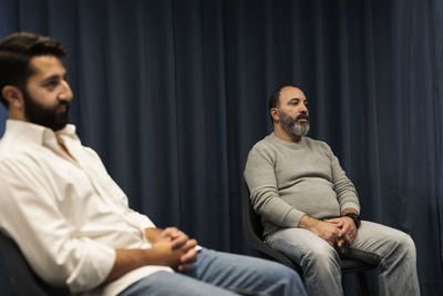 Men sitting during therapy meeting