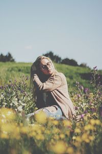 Young woman with flowers on field