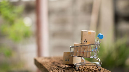 Close-up of cardboard boxes in small shopping cart on table