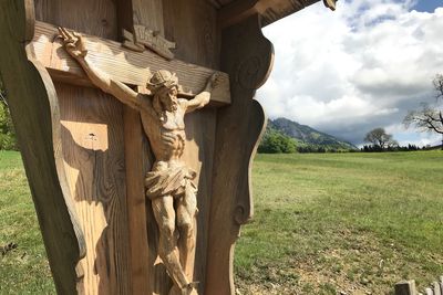 Statue on field against sky