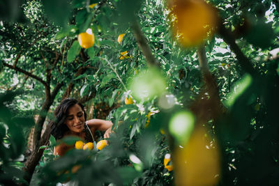 Young woman with plants in park