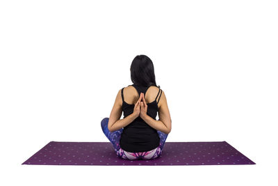 Full length of woman sitting against white background
