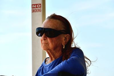 Young woman wearing sunglasses against sky