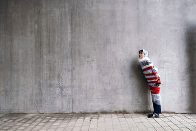 Protected young woman in bubble wrap standing on footpath