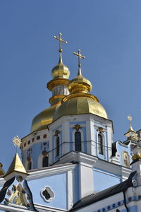 Low angle view of church and building against clear blue sky