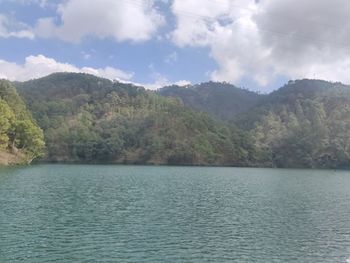 Scenic view of lake by mountain against sky