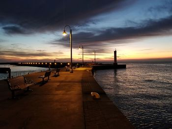 Pier over sea against sky during sunset