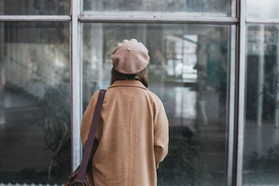 Rear view of woman standing towards modern building in city