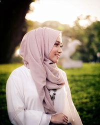 Smiling beautiful woman wearing hijab looking away at park