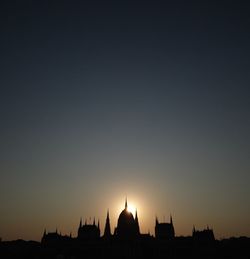 Silhouette buildings against sky during sunset