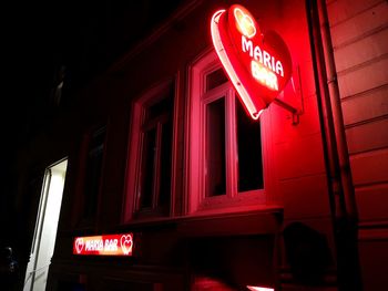 Low angle view of illuminated sign at night