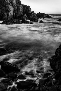 Scenic view of rocks in sea against sky