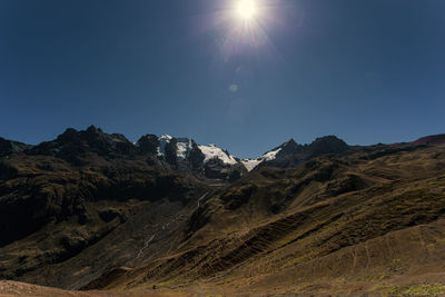 Scenic view of mountains against clear sky on sunny day